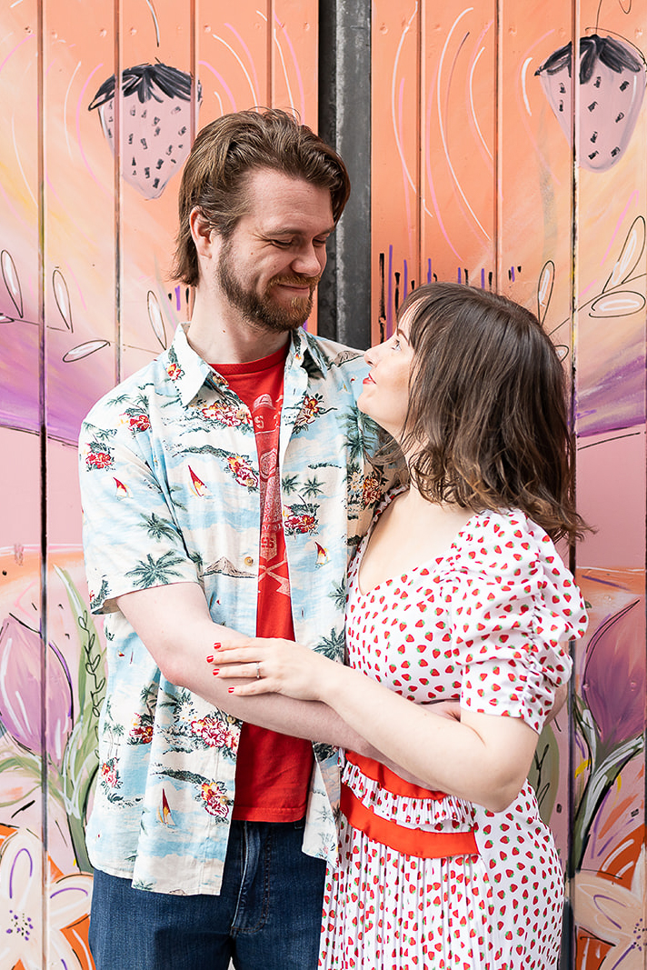 Engaged couple smiling at each other in Cathedral Quarter Belfast during engagement photoshoot